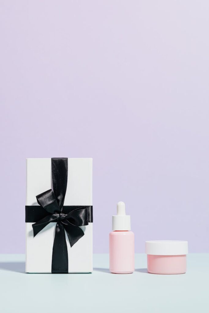 Minimalist display of pink beauty products with a gift box, perfect for promotions.